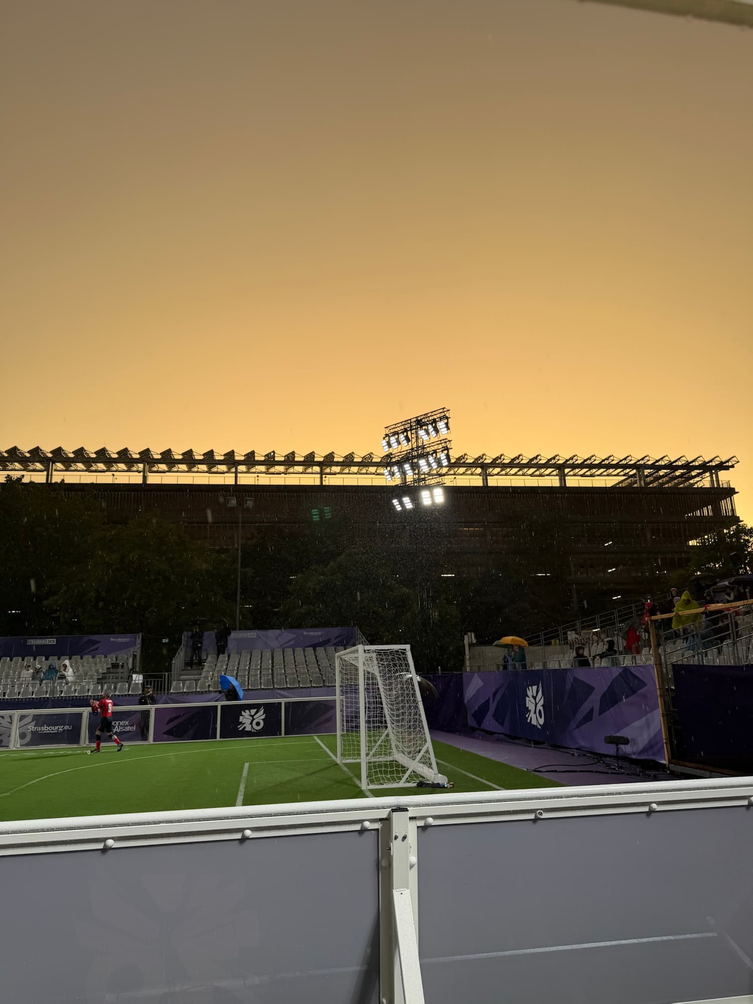 Coucher de soleil sur le stade de l’Euro de cécifoot à Strasbourg, ciel orangé au-dessus du terrain