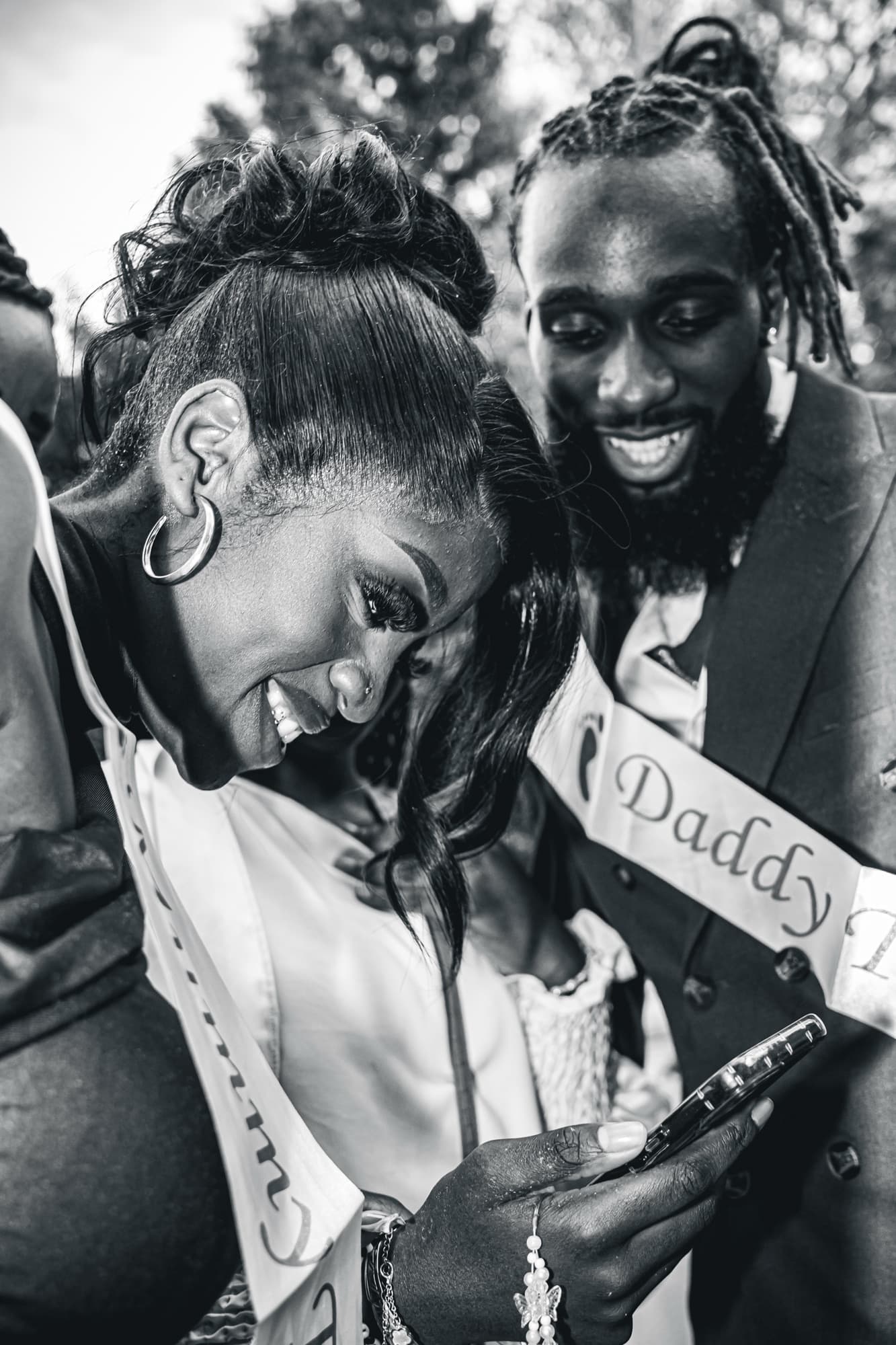 Le couple en noir et blanc, regards complices et sourires, écharpe « Daddy »