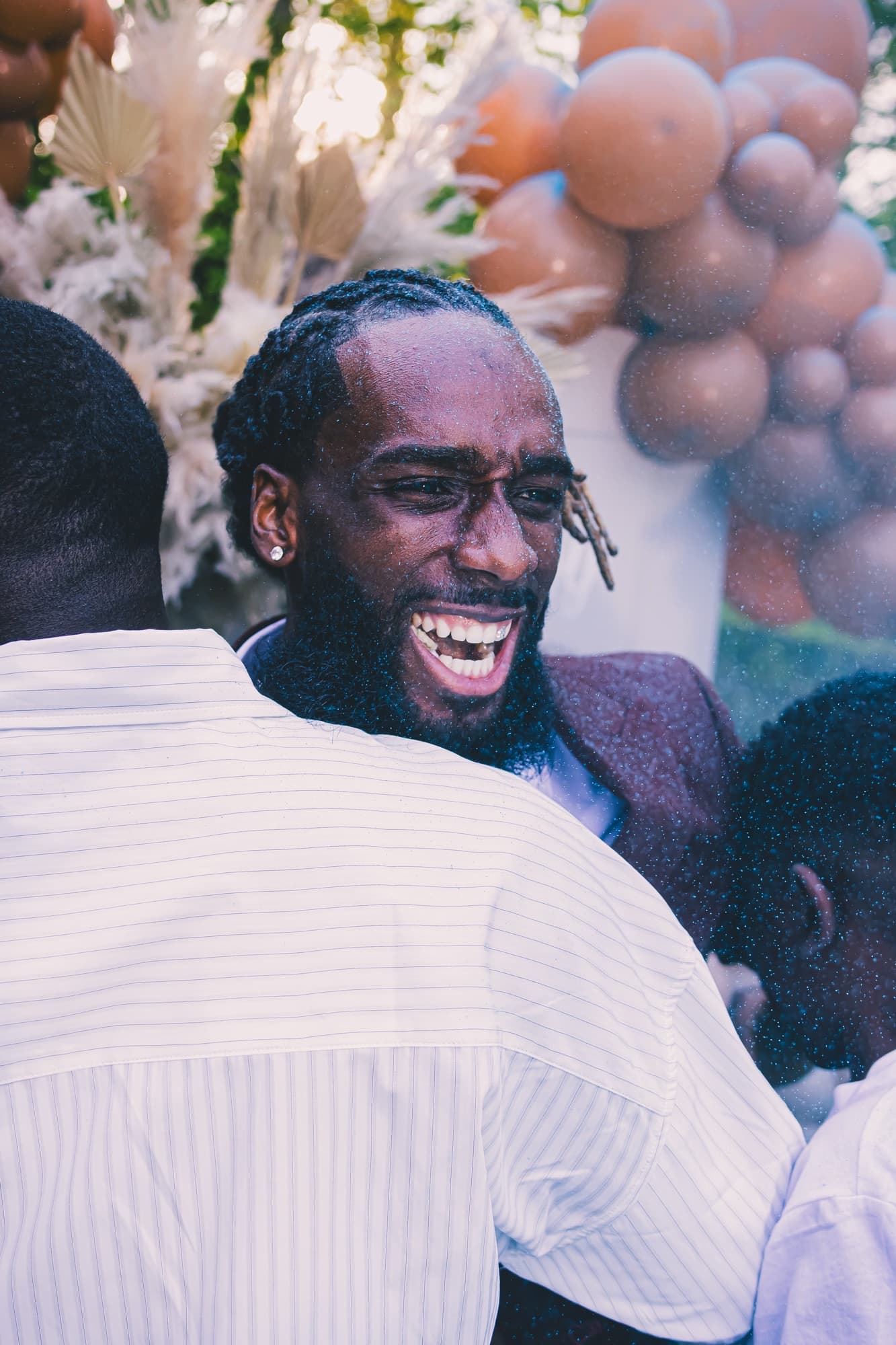 Le futur papa éclate de rire avec un ami pendant la fête, ambiance joyeuse