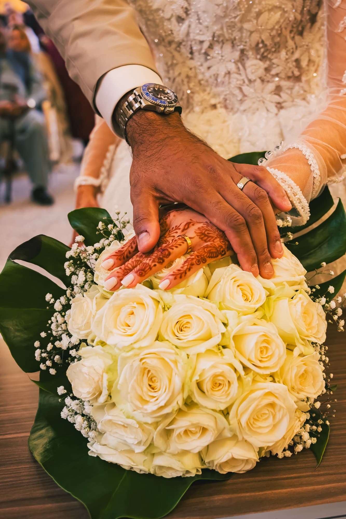 Le bouquet de roses blanches posé sur la table de la mairie, les mains des mariés avec le henné et l’alliance