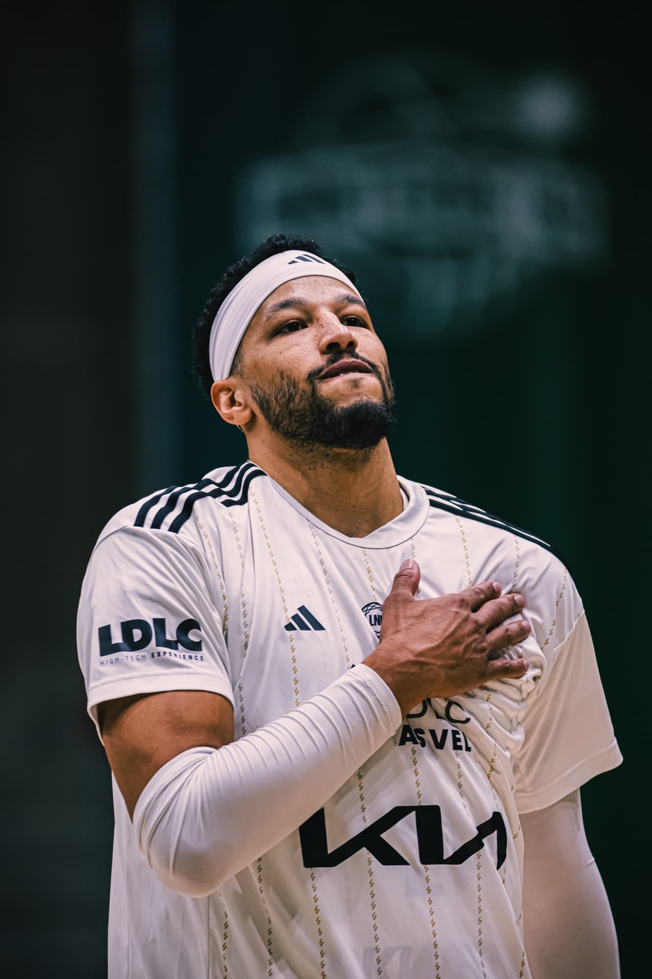 Un joueur d’ASVEL en blanc, la main sur le cœur, avant le match