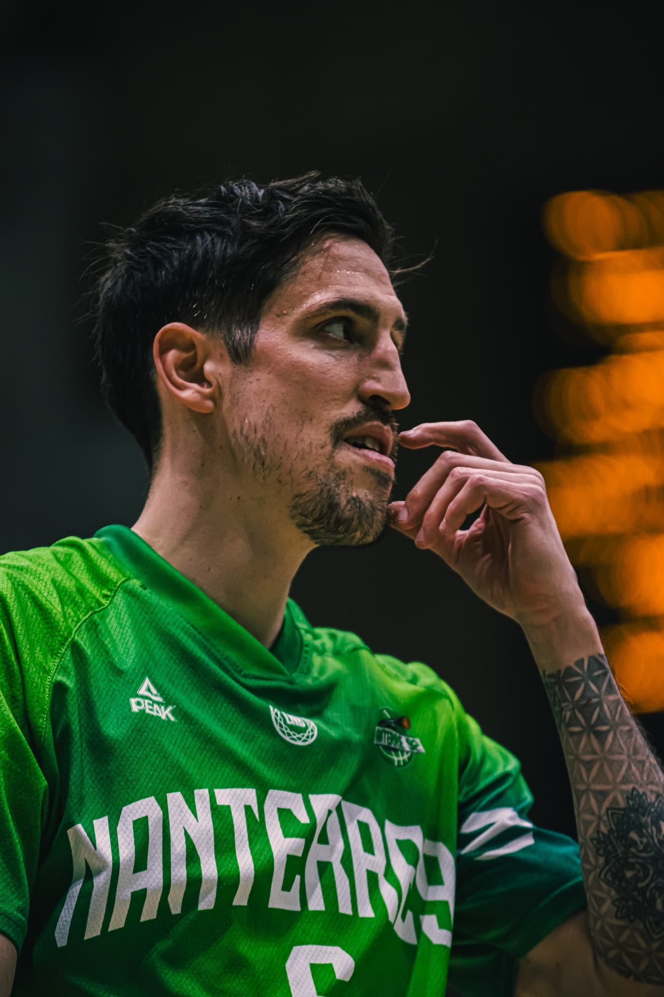 Un joueur de Nanterre 92, la main près du visage, concentré pendant le match