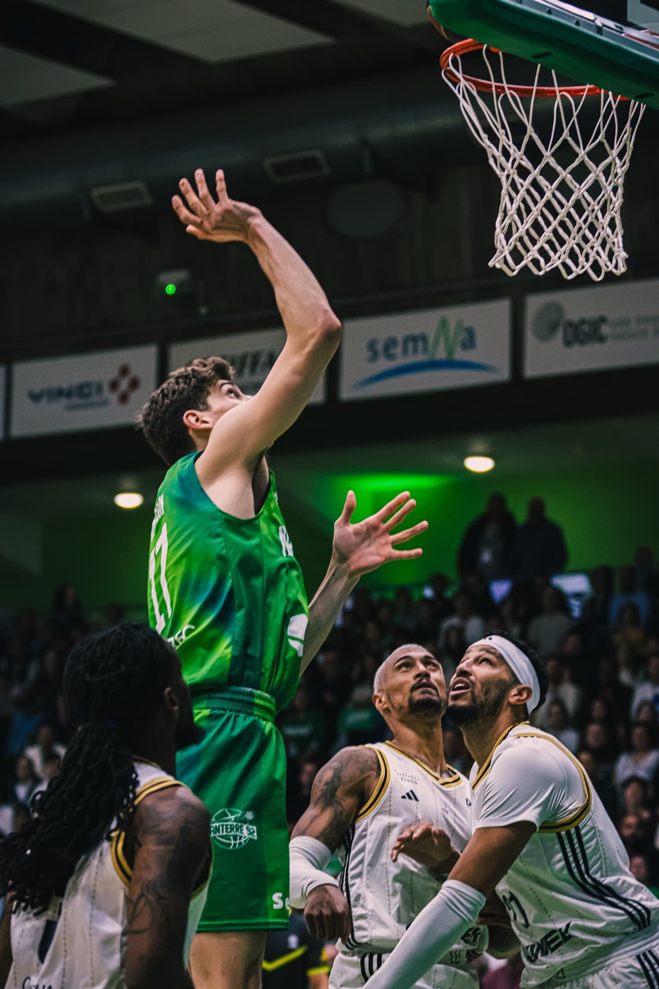 Un joueur de Nanterre 92 en l’air au tir, sous le panier et les défenseurs d’ASVEL
