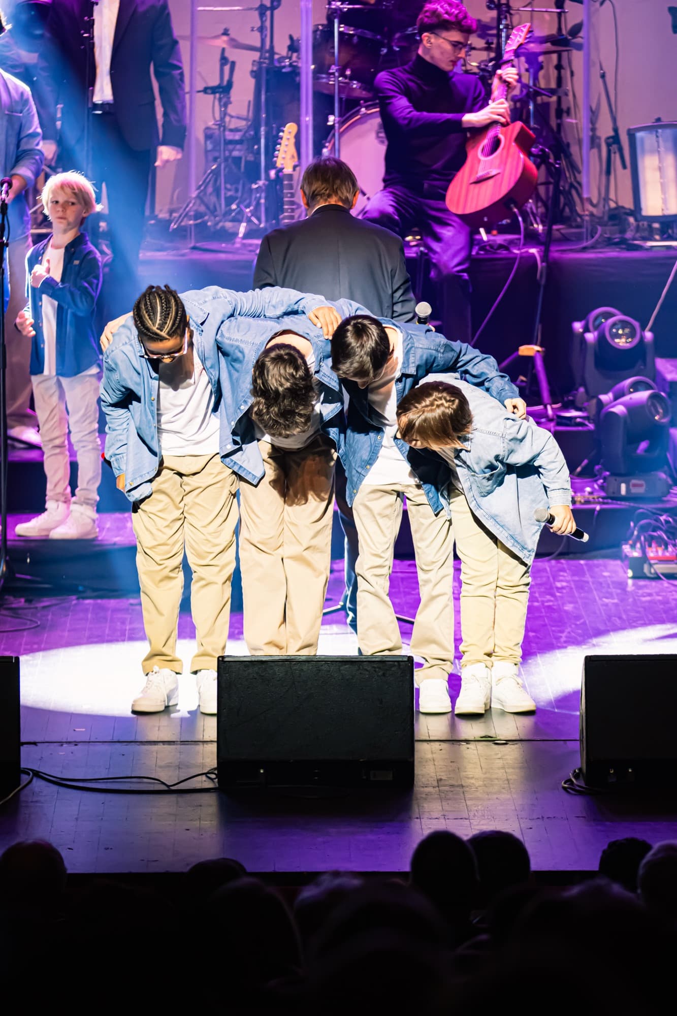 Les choristes saluent le public sur scène à la fin d’un morceau