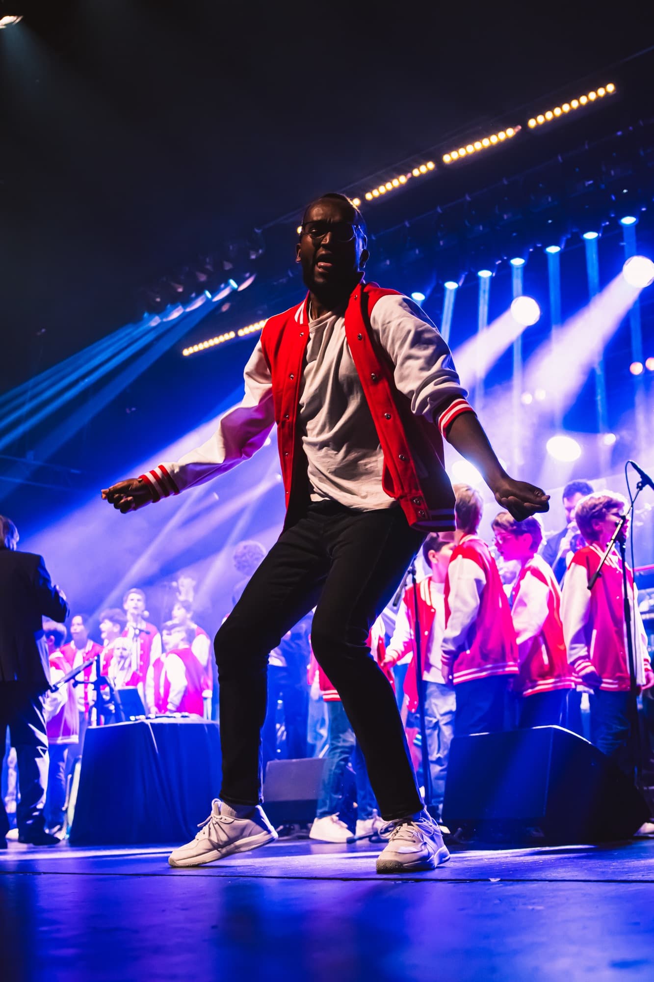 Un danseur en veste rouge, en plein mouvement devant le chœur