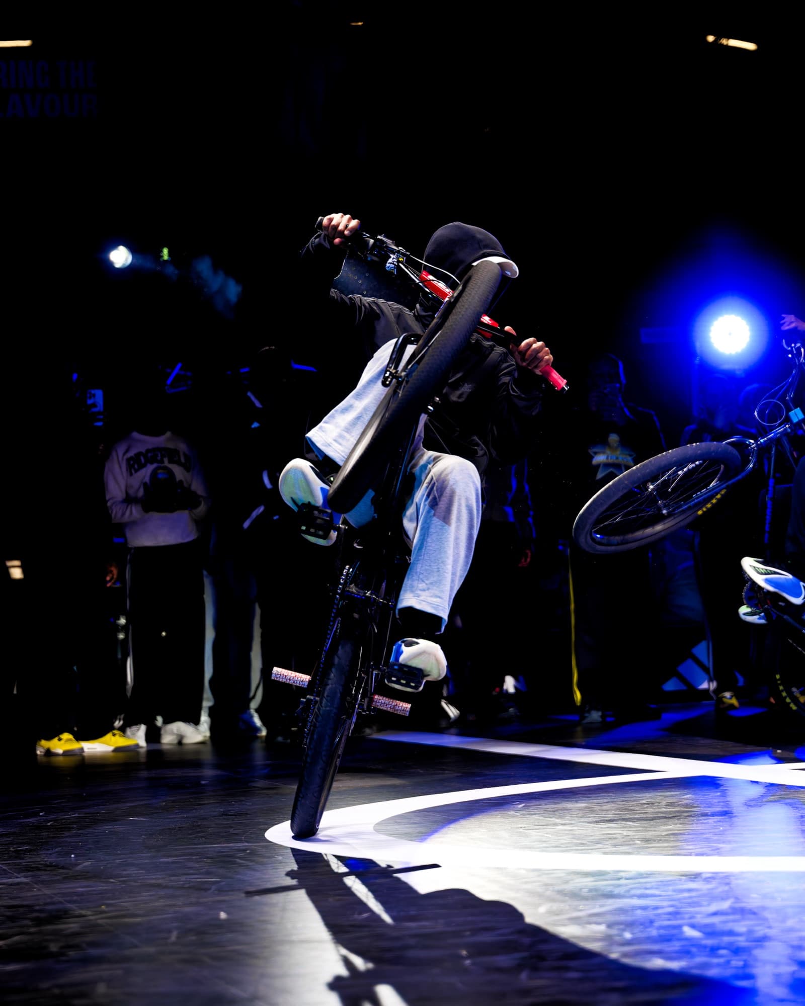 Rider de BMX en équilibre sur la roue arrière pendant un show sur le terrain
