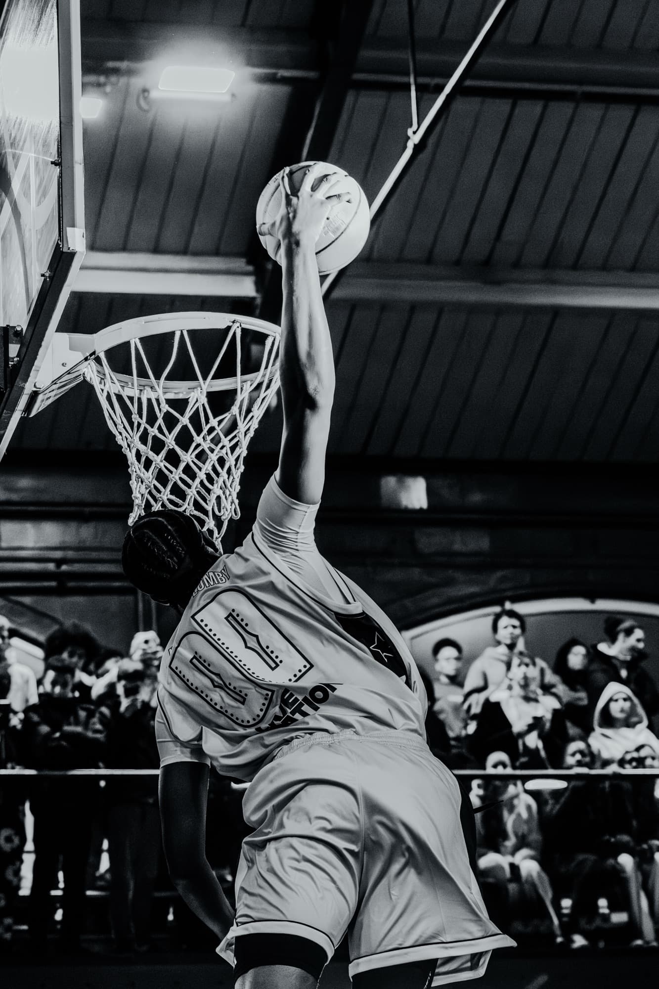 Dunk en noir et blanc, le joueur au bout de son geste