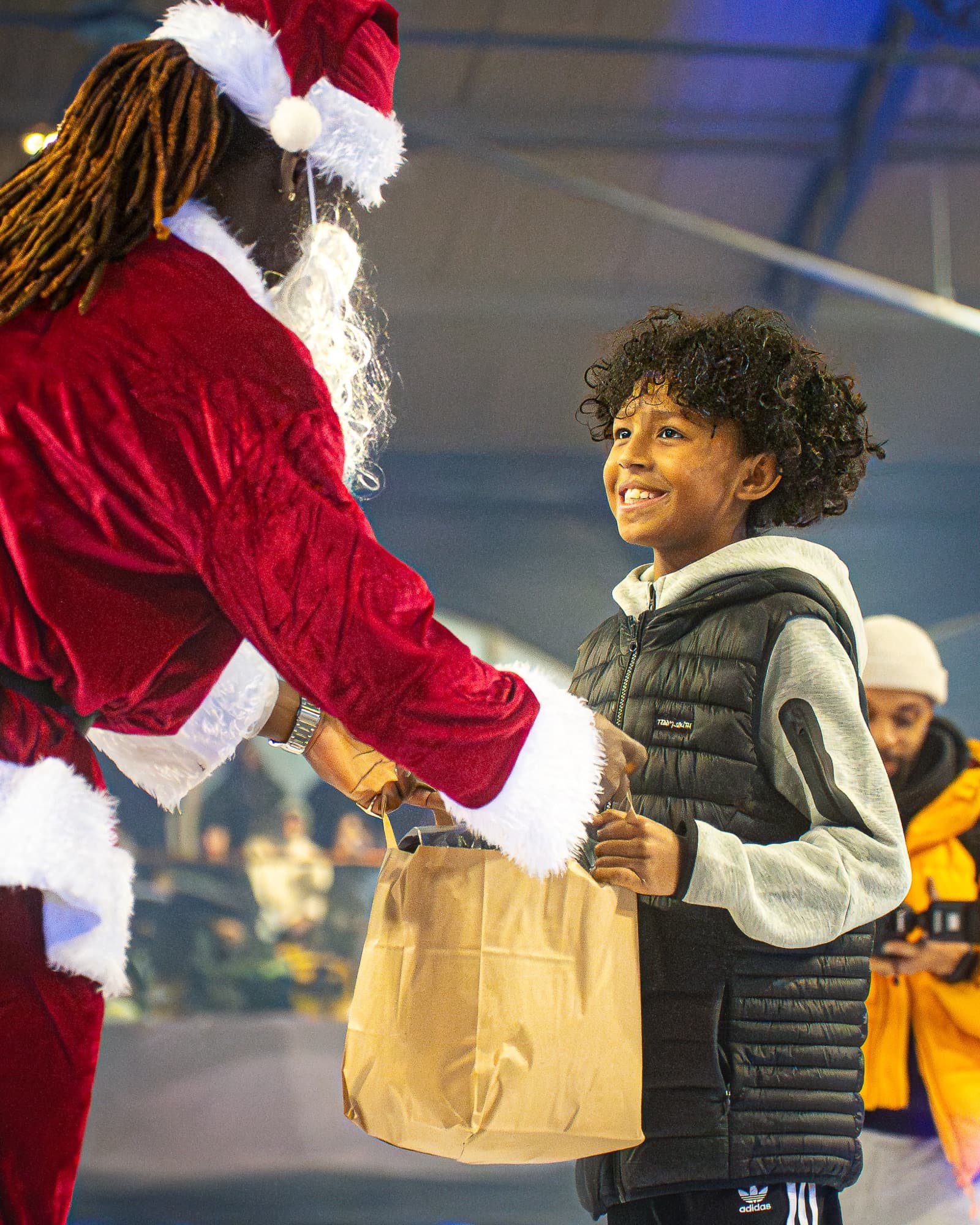 Le Père Noël remet un cadeau à un enfant sur le terrain