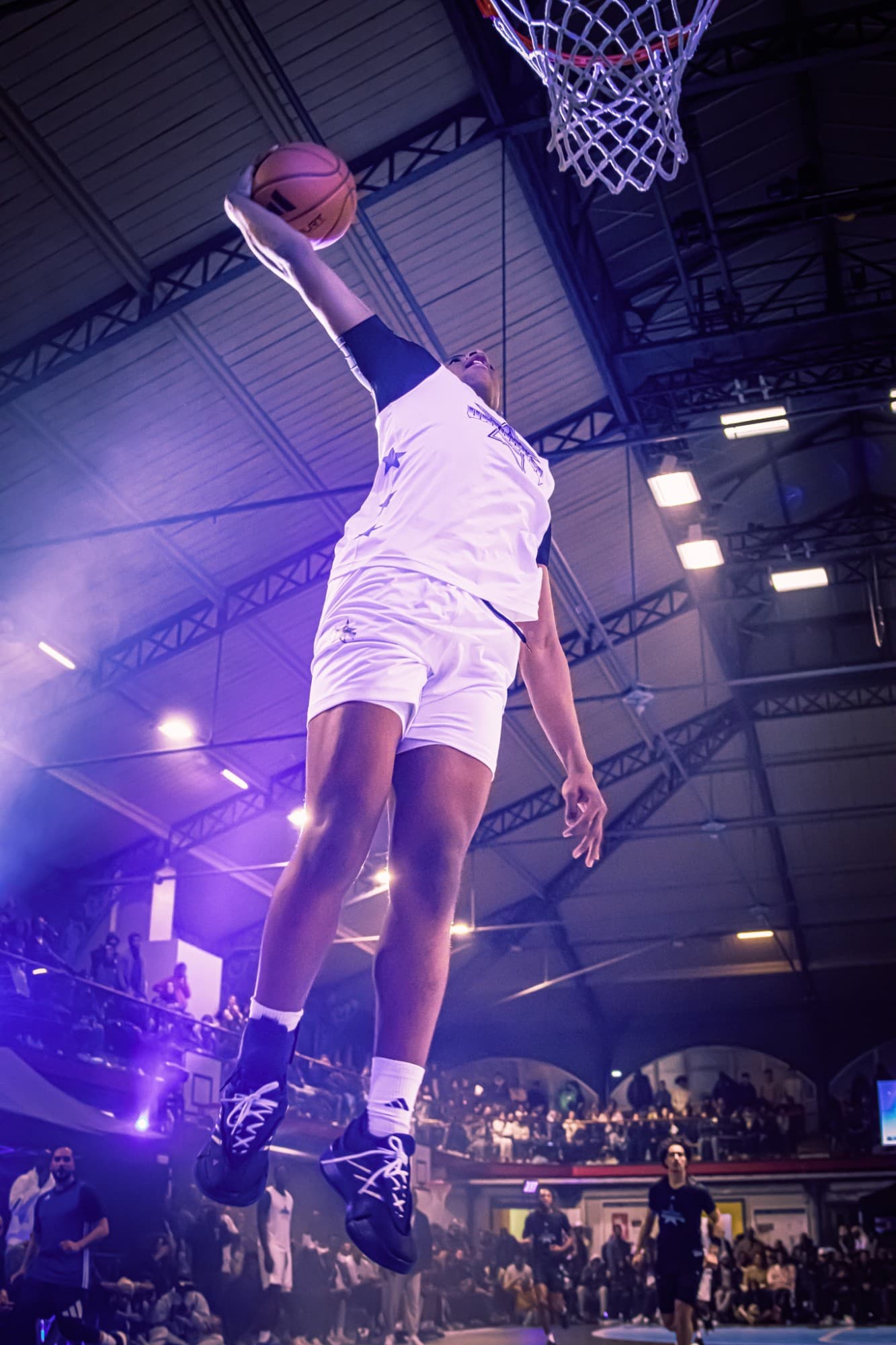 Joueur de basket en plein dunk, vu d’en dessous, sous des lumières violettes — Unlocked Winter Classic × adidas